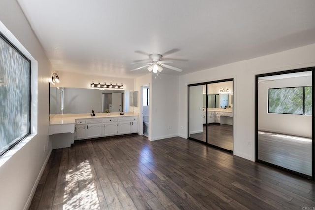 1279 Cypress Dr, Vista, CA 92084 - unfurnished bedroom featuring multiple windows, dark wood finished floors, connected bathroom, and multiple closets