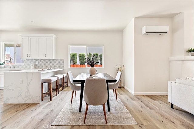 1251 Leighton Ave Unit 1251, Los Angeles, CA 90037 - dining space with a wall mounted AC, plenty of natural light, light wood-type flooring, and baseboards