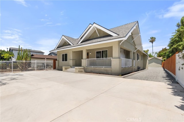 1251 Leighton Ave Unit 1251, Los Angeles, CA 90037 - view of front of property featuring a porch, stucco siding, a shingled roof, and driveway