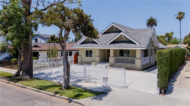 1251 Leighton Ave Unit 1251, Los Angeles, CA 90037 - view of front of property with a porch, roof with shingles, stucco siding, a gate, and a fenced front yard