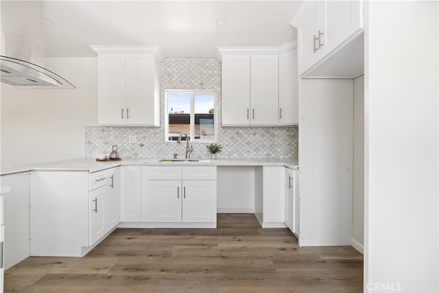 1251 Leighton Ave Unit 1251, Los Angeles, CA 90037 - kitchen featuring a sink, island exhaust hood, backsplash, white cabinetry, and wood finished floors