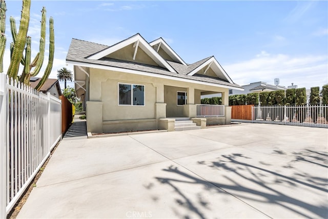1251 Leighton Ave Unit 1251, Los Angeles, CA 90037 - view of front of property with stucco siding, a shingled roof, and covered porch