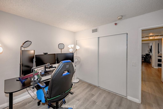 home office with wood finished floors and a textured ceiling