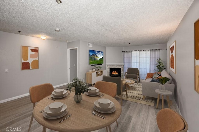 6545 Reseda Blvd Unit 3, Reseda, CA 91335 - dining area with light wood finished floors, a lit fireplace, and a textured ceiling