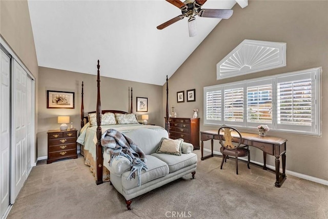 carpeted bedroom featuring a closet, high vaulted ceiling, baseboards, and a ceiling fan