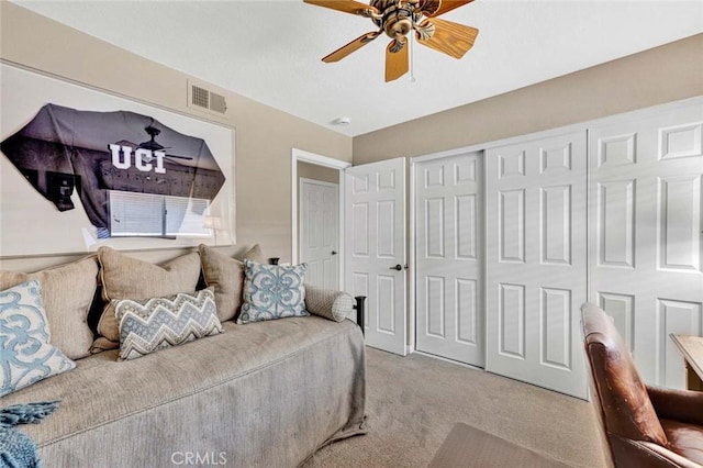 living area featuring light carpet and a ceiling fan