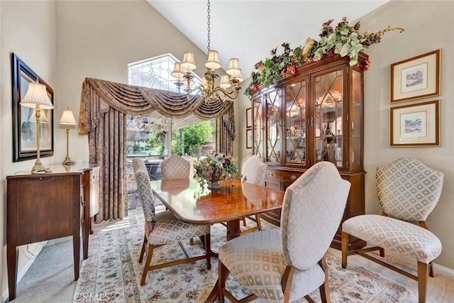 dining space featuring a chandelier, carpet, high vaulted ceiling, and baseboards
