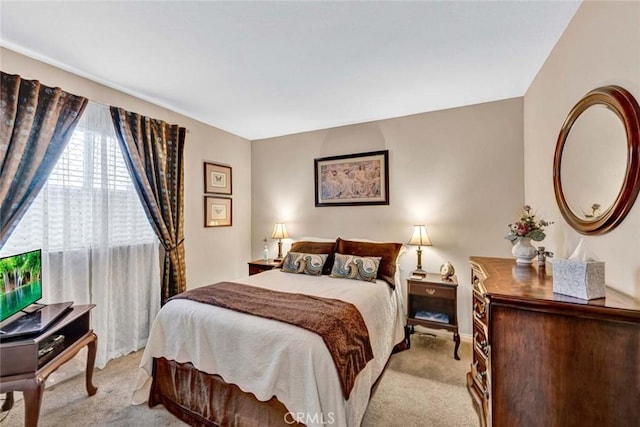 bedroom with light carpet and baseboards