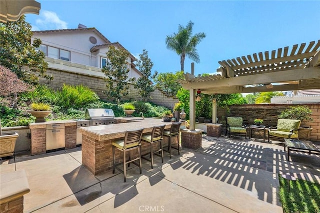 view of patio featuring area for grilling, fence, an outdoor kitchen, and a pergola