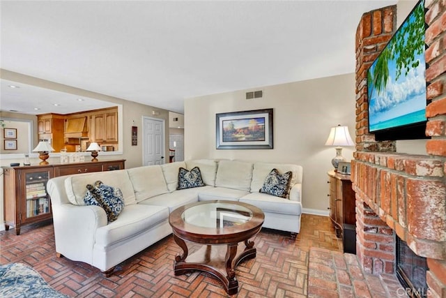 living room with brick floors, a fireplace, and baseboards