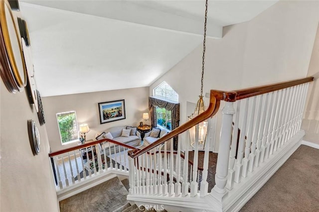 stairway with carpet, lofted ceiling, and baseboards