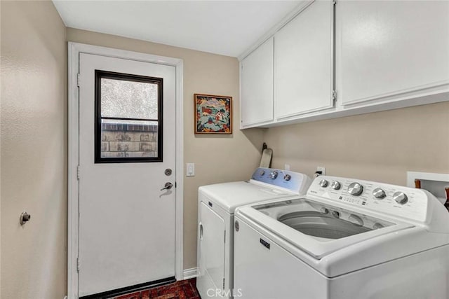 laundry area featuring washing machine and clothes dryer, cabinet space, and baseboards
