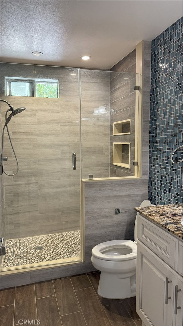 13442 Flower St Unit 15, Garden Grove, CA 92843 - bathroom featuring tile walls, a stall shower, vanity, wood finish floors, and recessed lighting