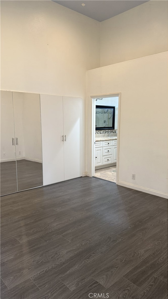 13442 Flower St Unit 15, Garden Grove, CA 92843 - unfurnished bedroom featuring a towering ceiling, dark wood-style floors, a closet, and ensuite bathroom