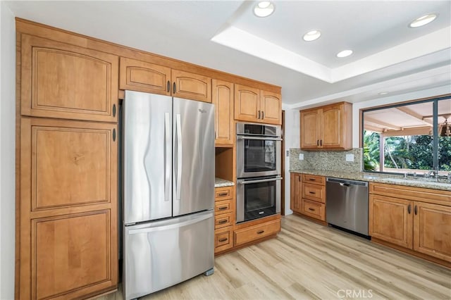 24752 Via, San Anselmo, Mission Viejo, CA 92692 - kitchen with appliances with stainless steel finishes, light stone countertops, light wood-type flooring, recessed lighting, and decorative backsplash