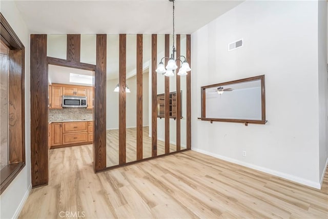 24752 Via, San Anselmo, Mission Viejo, CA 92692 - unfurnished bedroom with a chandelier, light wood finished floors, and baseboards