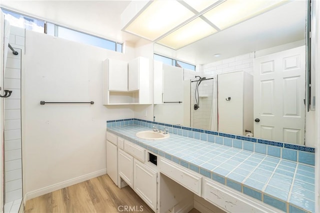 24752 Via, San Anselmo, Mission Viejo, CA 92692 - bathroom with a tile shower, plenty of natural light, wood finished floors, and vanity