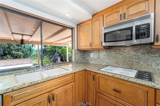 24752 Via, San Anselmo, Mission Viejo, CA 92692 - kitchen with stainless steel microwave, light stone counters, a sink, and tasteful backsplash