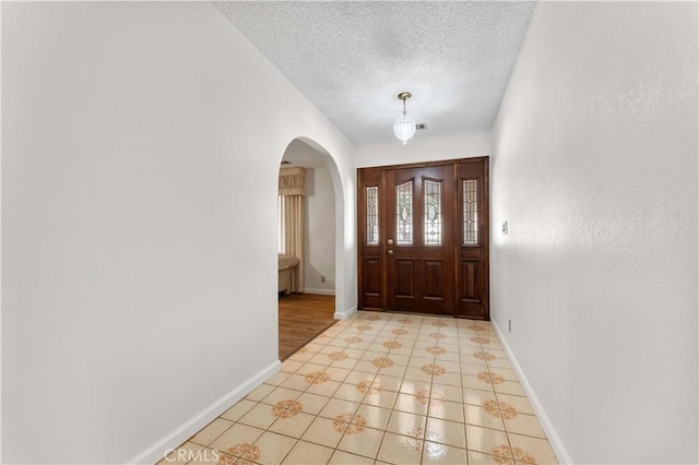 6367 Arrowhead Lake Rd, Hesperia, CA 92345 - foyer with arched walkways, a textured ceiling, and light tile patterned flooring
