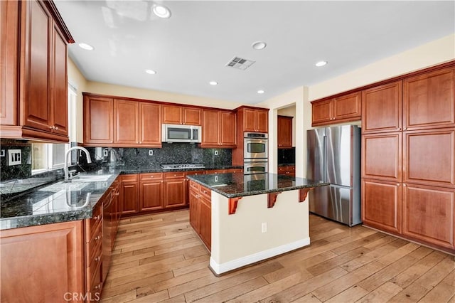 8 Via Del Fico Ct, Lake Elsinore, CA 92532 - kitchen featuring appliances with stainless steel finishes, a sink, a center island, light wood finished floors, and recessed lighting
