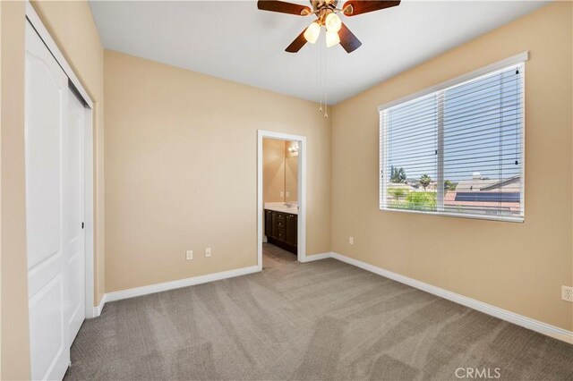 8 Via Del Fico Ct, Lake Elsinore, CA 92532 - unfurnished bedroom featuring light carpet, a closet, baseboards, connected bathroom, and a ceiling fan