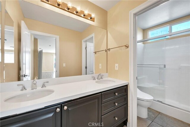 8 Via Del Fico Ct, Lake Elsinore, CA 92532 - bathroom featuring double vanity, toilet, a stall shower, and tile patterned floors