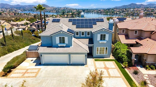 8 Via Del Fico Ct, Lake Elsinore, CA 92532 - traditional-style house featuring a garage, solar panels, a residential view, concrete driveway, and a water and mountain view