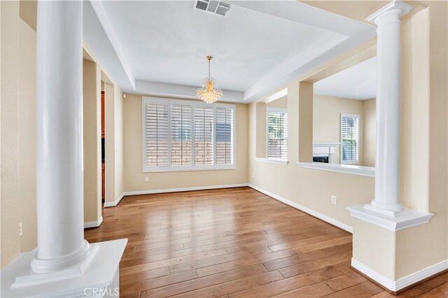 8 Via Del Fico Ct, Lake Elsinore, CA 92532 - unfurnished dining area with a tray ceiling, hardwood / wood-style floors, baseboards, and ornate columns