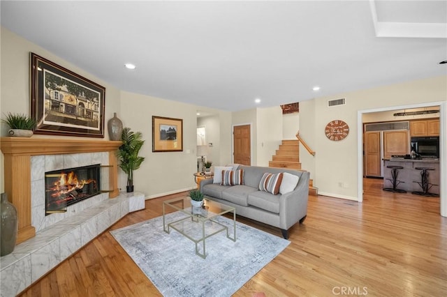 5894 E Appian Way, Long Beach, CA 90803 - living area featuring stairs, baseboards, light wood-style flooring, a tiled fireplace, and recessed lighting