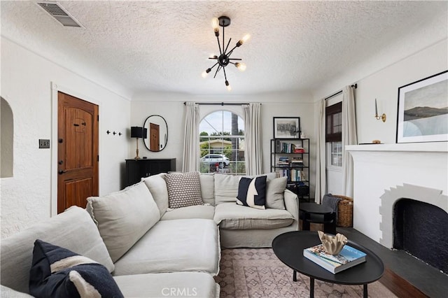 6062 Gaviota Ave, Long Beach, CA 90805 - living area featuring a chandelier, a textured ceiling, and a fireplace