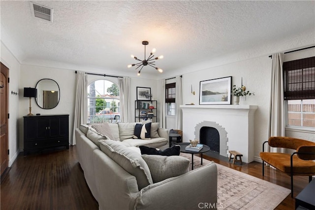 6062 Gaviota Ave, Long Beach, CA 90805 - living room with a textured ceiling, a chandelier, dark wood finished floors, baseboards, and a brick fireplace