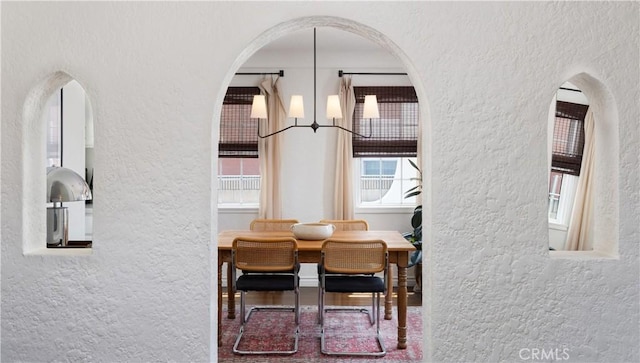6062 Gaviota Ave, Long Beach, CA 90805 - dining space featuring a textured wall, healthy amount of natural light, and arched walkways
