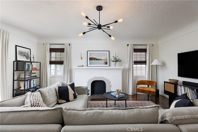 6062 Gaviota Ave, Long Beach, CA 90805 - living area featuring wood finished floors, a chandelier, a fireplace with flush hearth, a textured ceiling, and baseboards