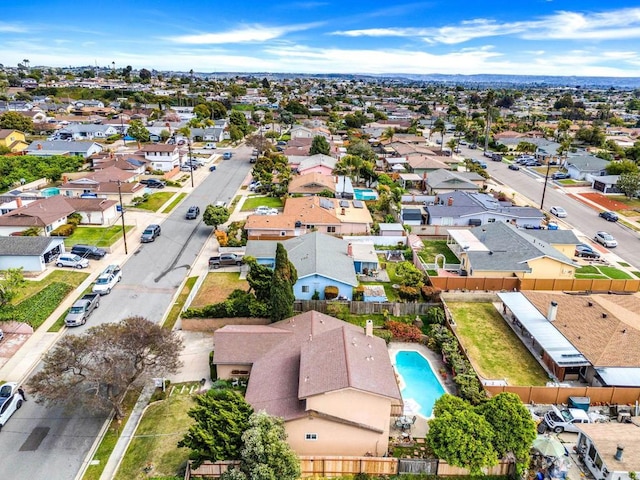 aerial view of property and surrounding area featuring nearby suburban area and a pool area