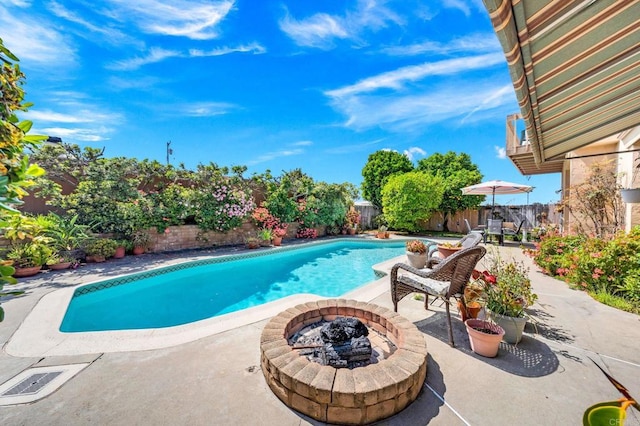 view of pool featuring an outdoor fire pit, a patio area, and a fenced backyard