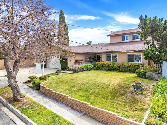 view of front of property with stucco siding, a front lawn, driveway, and a garage