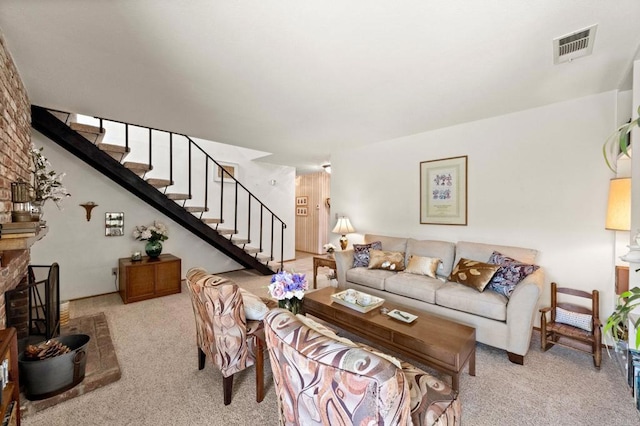 living area featuring carpet floors, stairway, and a fireplace
