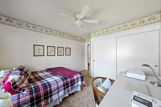 bedroom featuring a closet, carpet flooring, an office area, and a ceiling fan
