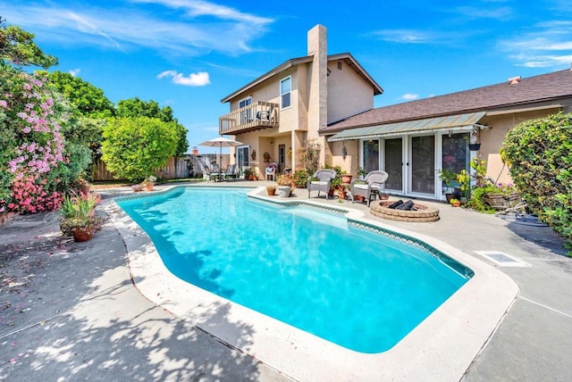 view of swimming pool with a patio area, fence, french doors, and an outdoor fire pit