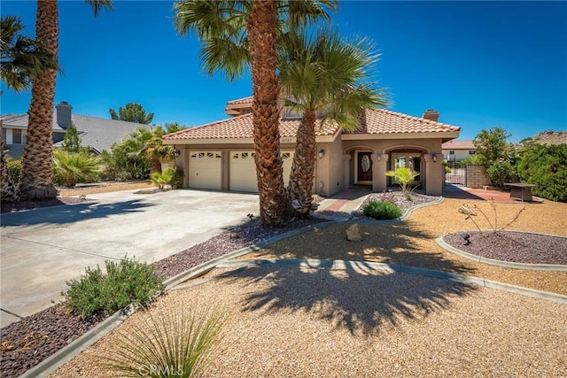 16350 Ridge View Dr, Apple Valley, CA 92307 - mediterranean / spanish-style house featuring stucco siding, concrete driveway, a garage, and a chimney