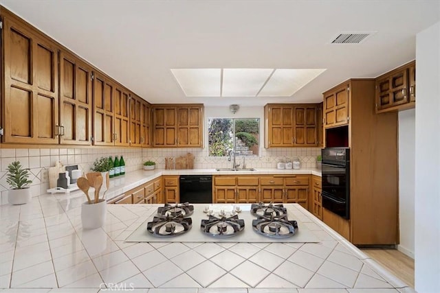 4180 Mount Baldy Ct, Norco, CA 92860 - kitchen featuring black appliances, a sink, a warming drawer, tasteful backsplash, and brown cabinetry