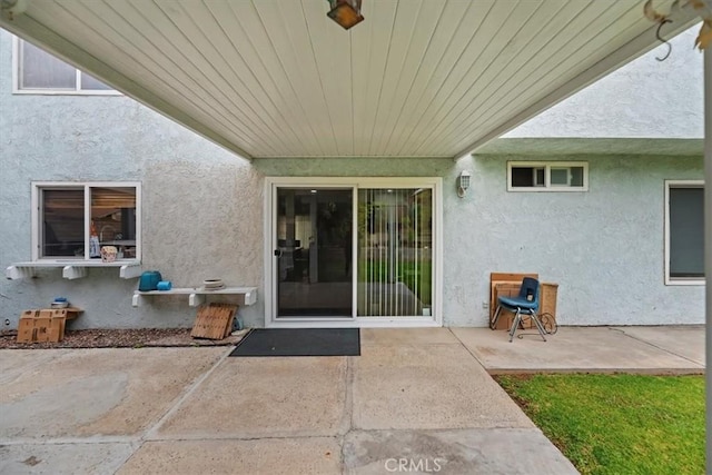 doorway to property with stucco siding and a patio