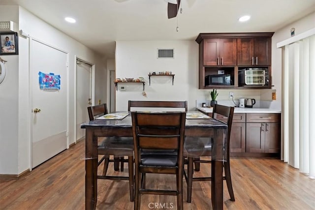 kitchen featuring black microwave, a ceiling fan, wood finished floors, recessed lighting, and dark brown cabinetry