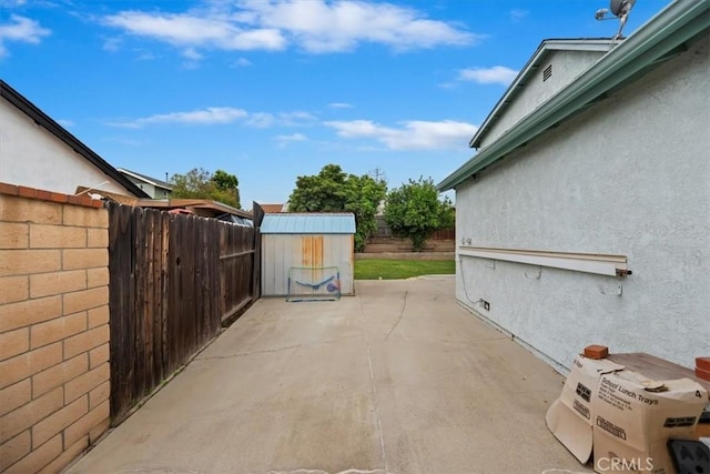 view of patio / terrace with a storage unit, an outbuilding, and a fenced backyard
