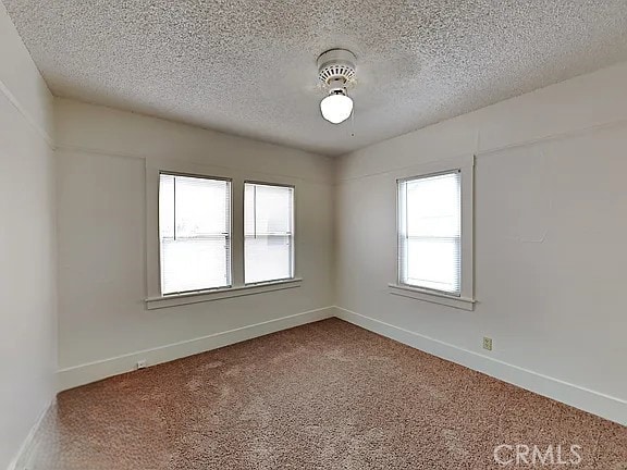 4890 7th Ave, Sacramento, CA 95820 - unfurnished room featuring carpet flooring, a textured ceiling, baseboards, and a ceiling fan