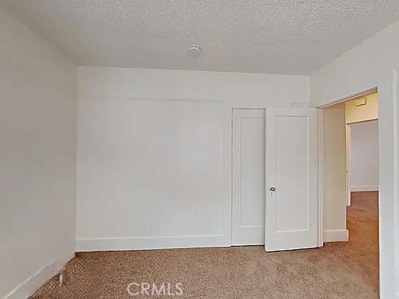 4890 7th Ave, Sacramento, CA 95820 - carpeted spare room featuring a smoke detector, baseboards, and a textured ceiling