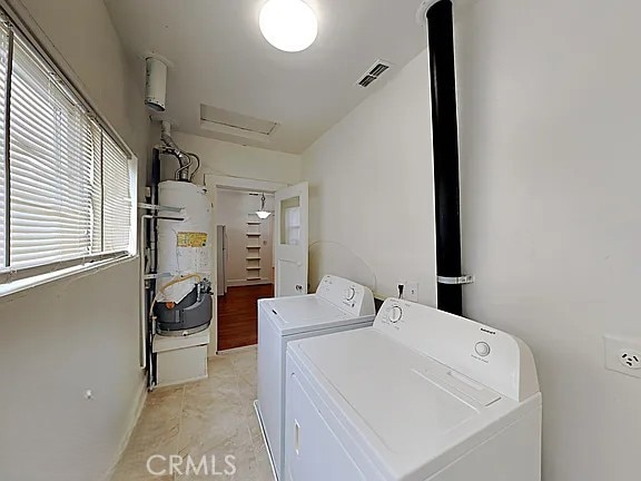 4890 7th Ave, Sacramento, CA 95820 - laundry area featuring independent washer and dryer, attic access, baseboards, water heater, and light tile patterned floors