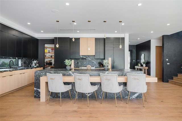 5141 Varna Ave, Sherman Oaks, CA 91423 - kitchen featuring modern cabinets, a sink, a kitchen breakfast bar, dark countertops, and a large island