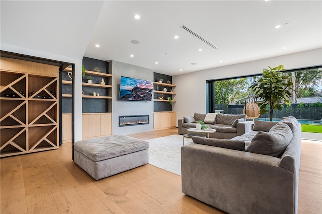 5141 Varna Ave, Sherman Oaks, CA 91423 - living area featuring built in shelves, plenty of natural light, light wood-type flooring, recessed lighting, and a glass covered fireplace