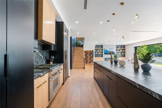 5141 Varna Ave, Sherman Oaks, CA 91423 - kitchen featuring modern cabinets, high end stainless steel range oven, dark countertops, decorative backsplash, and freestanding refrigerator